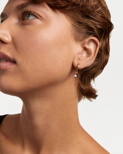 Aros de plata bañada en oro con un colgante de circonita azul en forma de gota