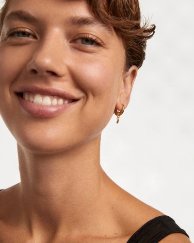 Aros de plata bañada en oro con un colgante de circonita verde en forma de gota