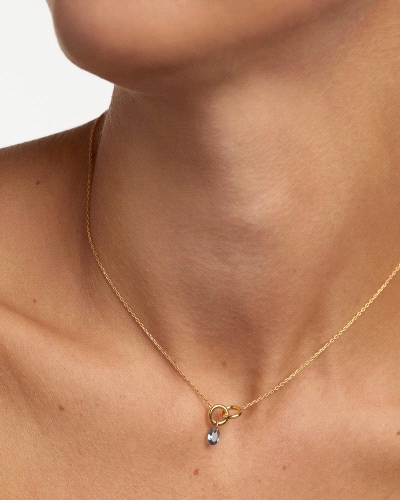 Collar con dos anillos entrelazados y un colgante de circonita azul en forma de gota