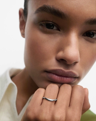 Anillo elegante de plata adornado con circonitas y líneas fluidas.