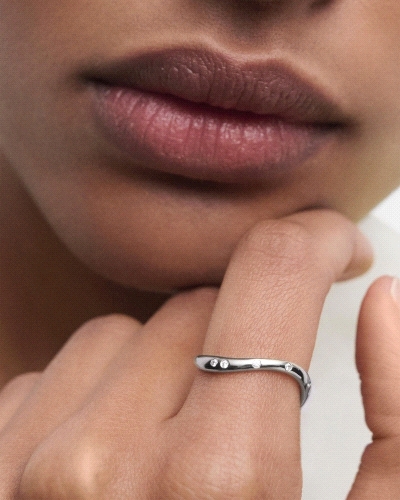 Anillo elegante de plata adornado con circonitas y líneas fluidas.